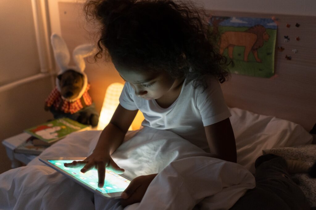 Little girl on an ipad in bed 